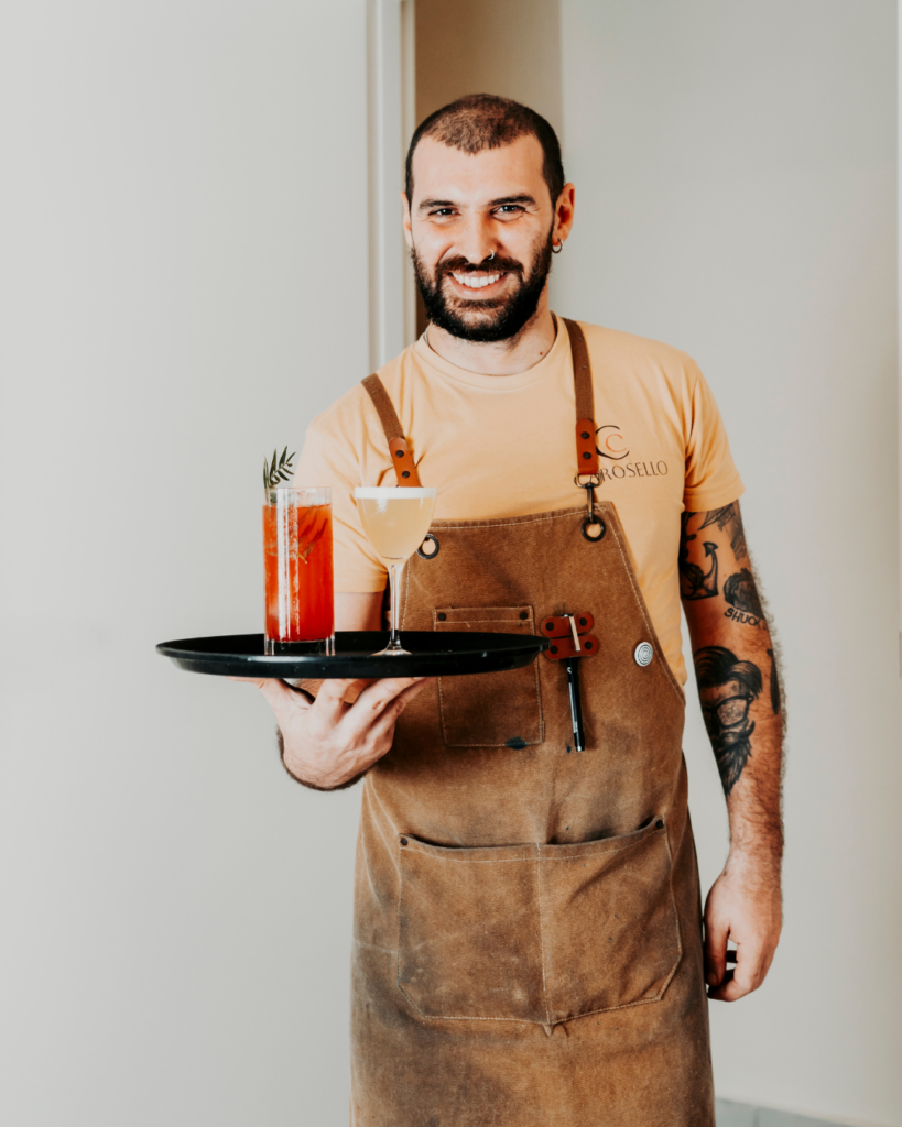 Servizio bar al B&B Carosello: ragazzo che porta un vassoio con due cocktail freschi per gli ospiti all'Isola d'Elba.