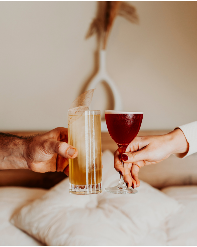 Brindisi di benvenuto al B&B Carosello: due ospiti che fanno cin-cin con cocktail colorati in camera all'Isola d'Elba.