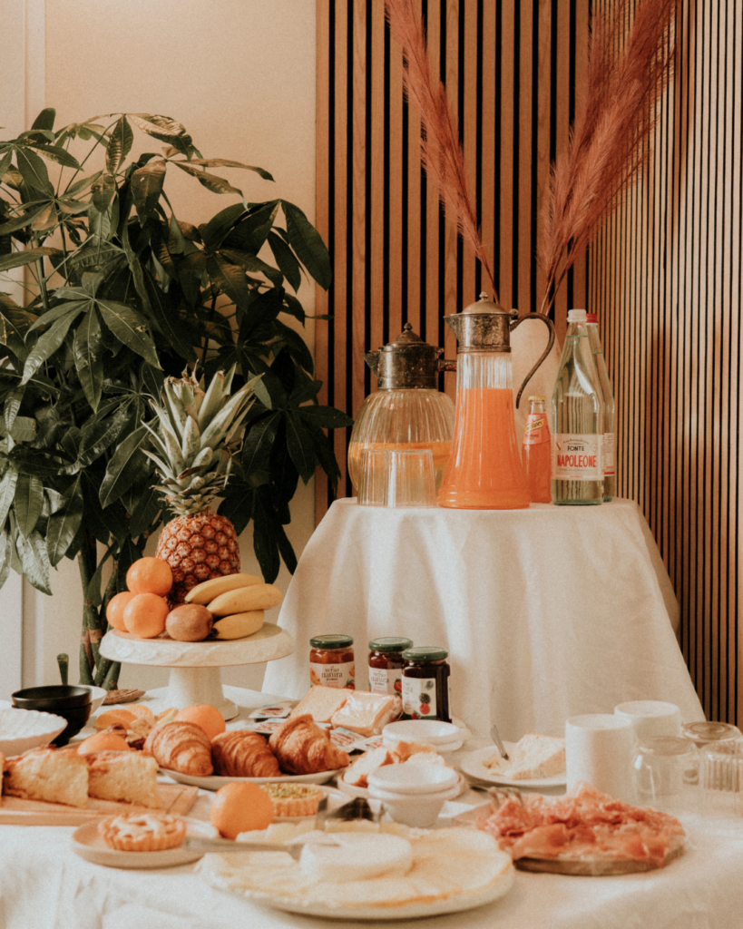 Ricco buffet della colazione al B&B Carosello: tavolo con torte artigianali, brioches fresche, salumi, formaggi e frutta all'Isola d'Elba.